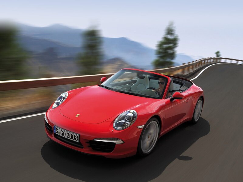 Red Porsche convertible on winding road