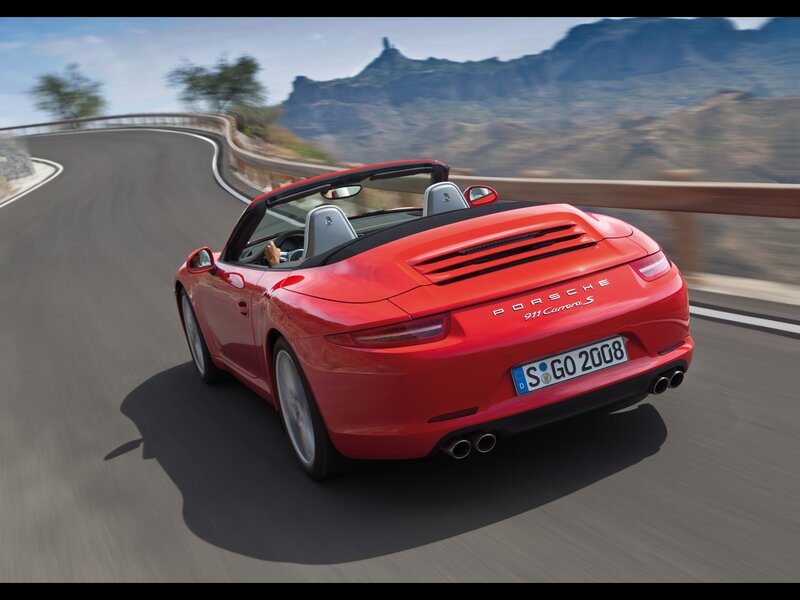 Red Porsche driving on a winding road