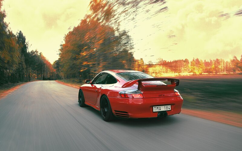 Red Porsche GT2 on a forest road