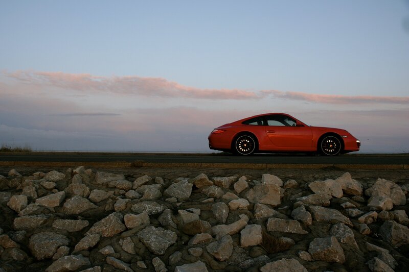 Red Porsche on coastal road