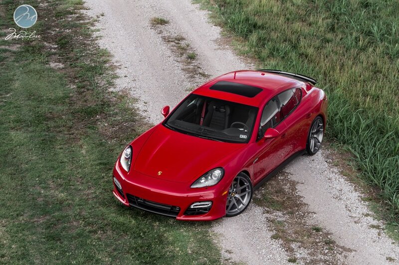 Red Porsche Panamera on gravel path
