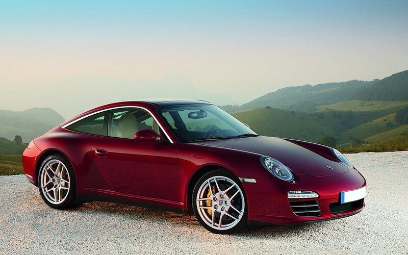 Red Porsche sports car on gravel