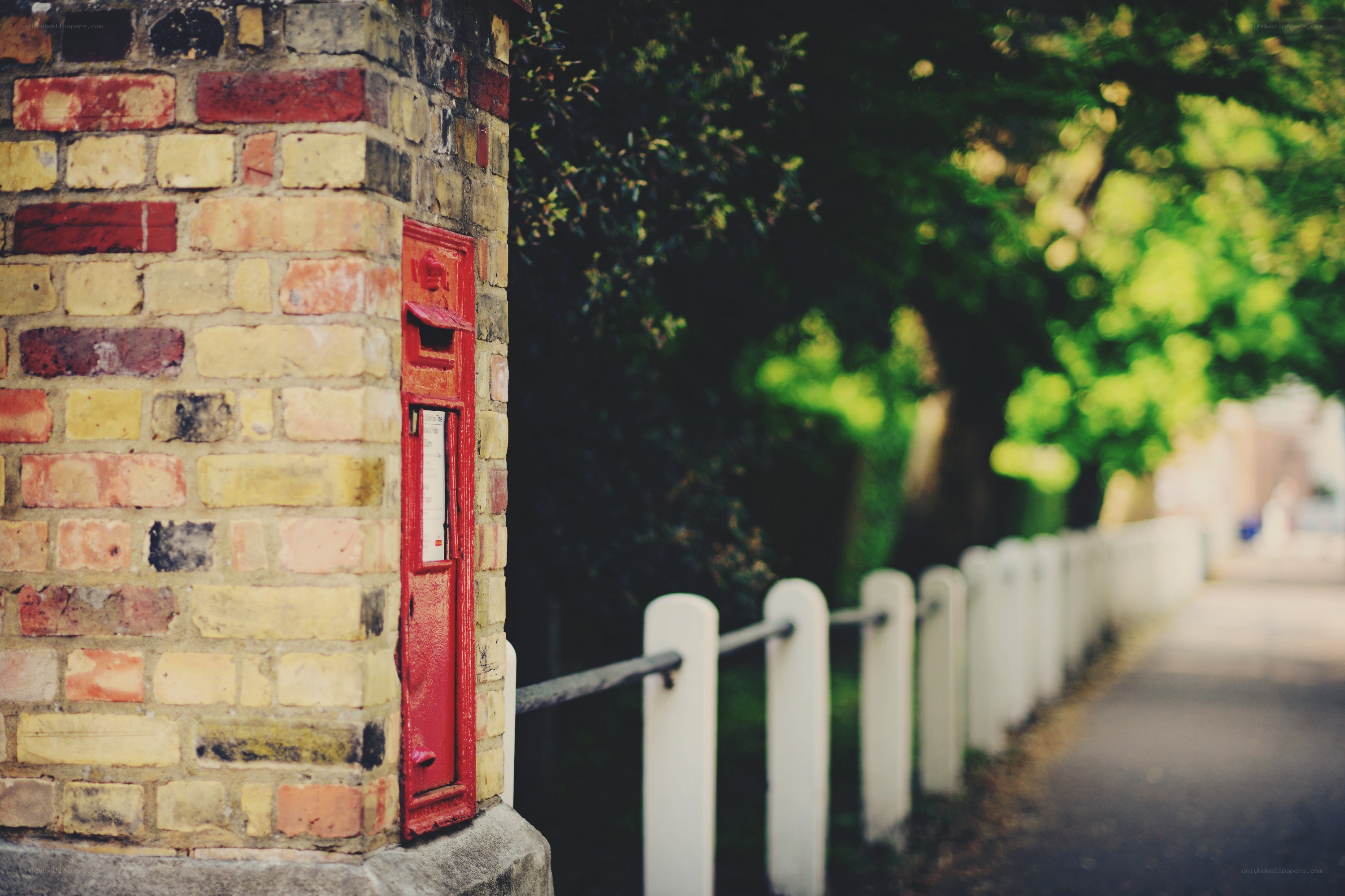 Red post box on brick wall