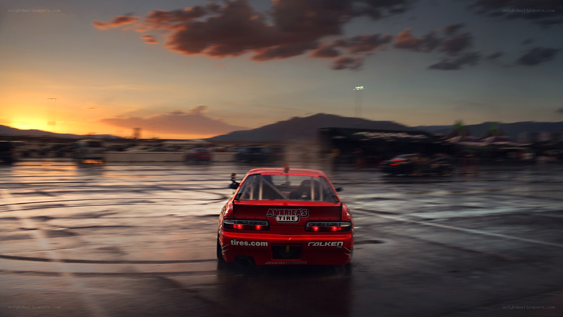 Red race car drifting at sunset