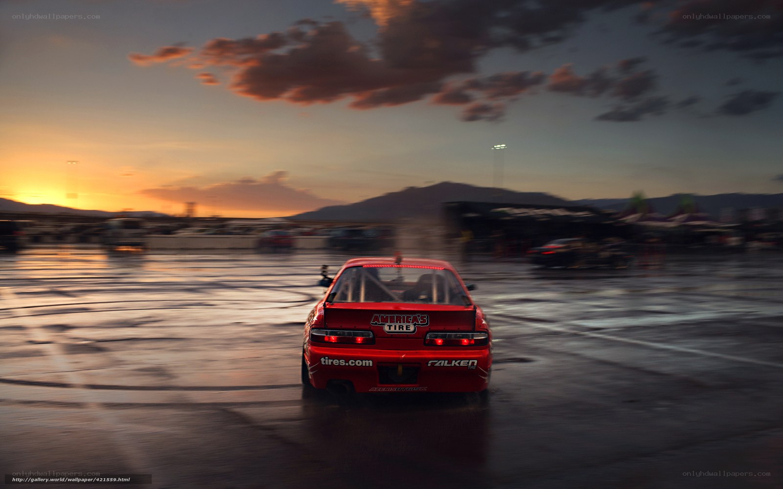 Red race car drifting at sunset