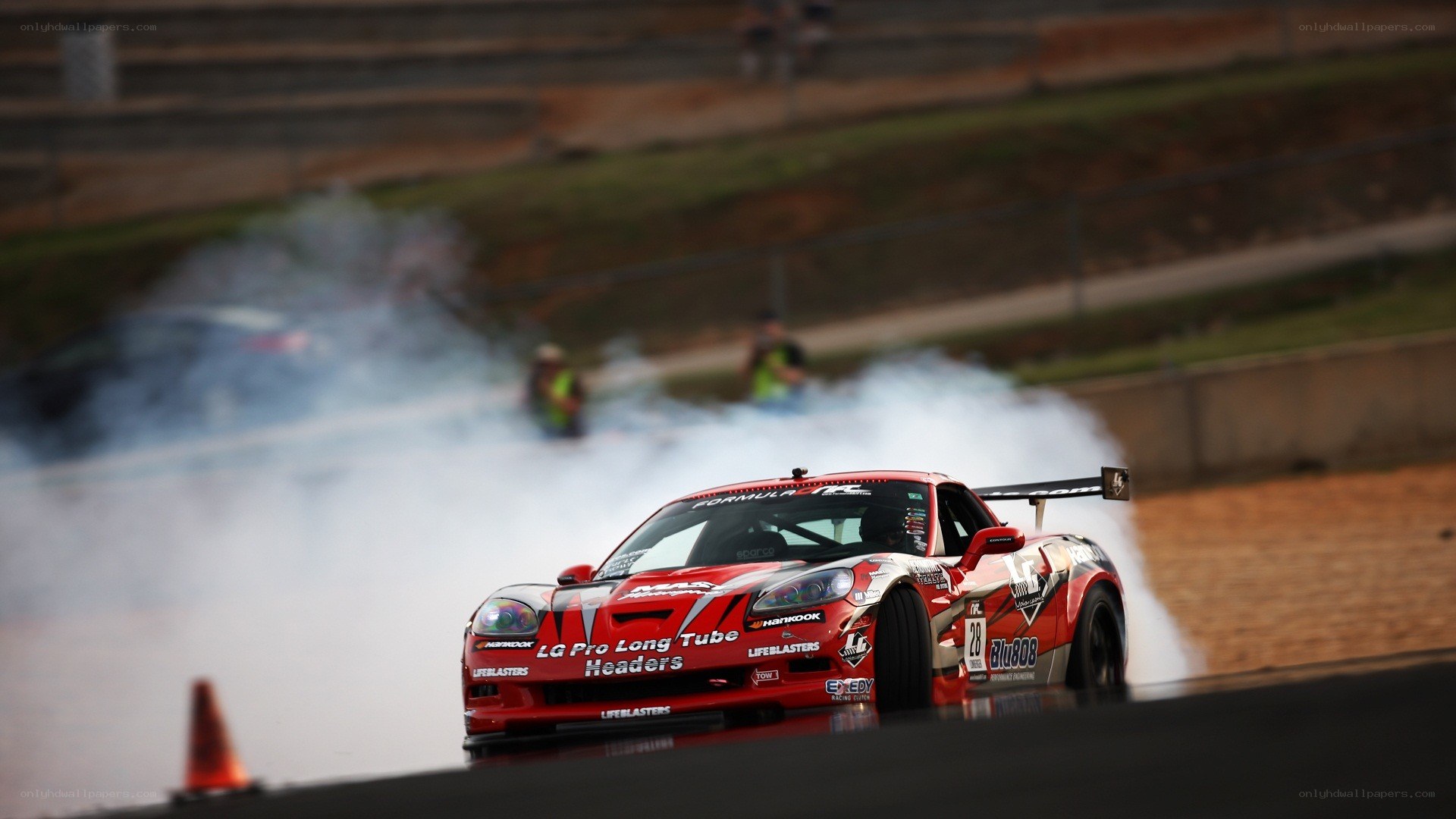 Red race car drifting on track