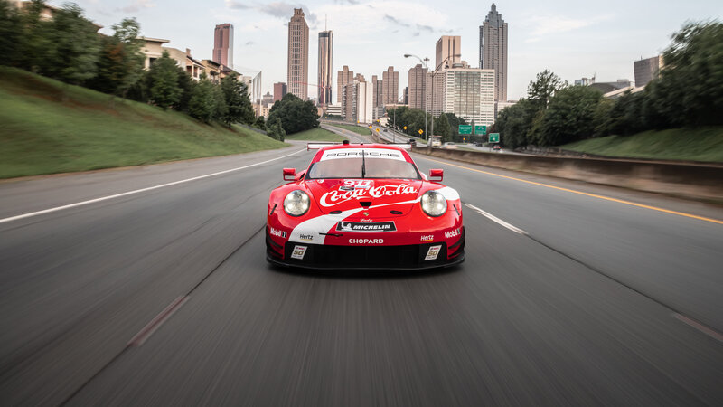 Red Race Car on Road — Dynamic, Afternoon, Photograph, City Skyline
