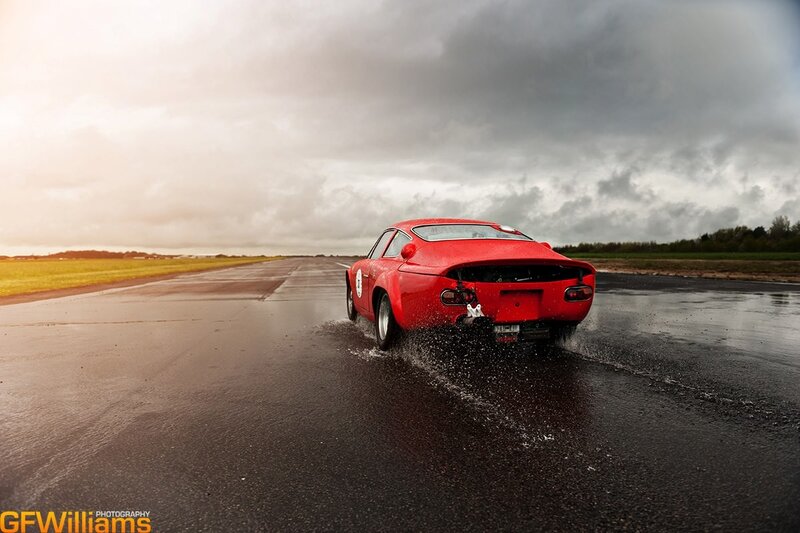 Red Race Car on Track — Dramatic, Afternoon, Photograph, Wet Road, Cloudy Sky
