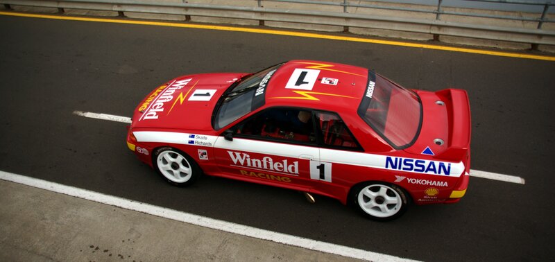 Red Race Car on Track — Dynamic, Photograph, Race Car, Guardrail, White