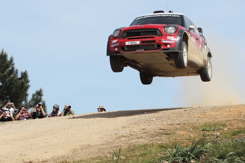 Red Rally Car in Mid-air — Dynamic, Afternoon, Photograph, Spectators, Dirt Track
