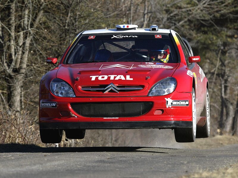 Red rally car in mid-air jump