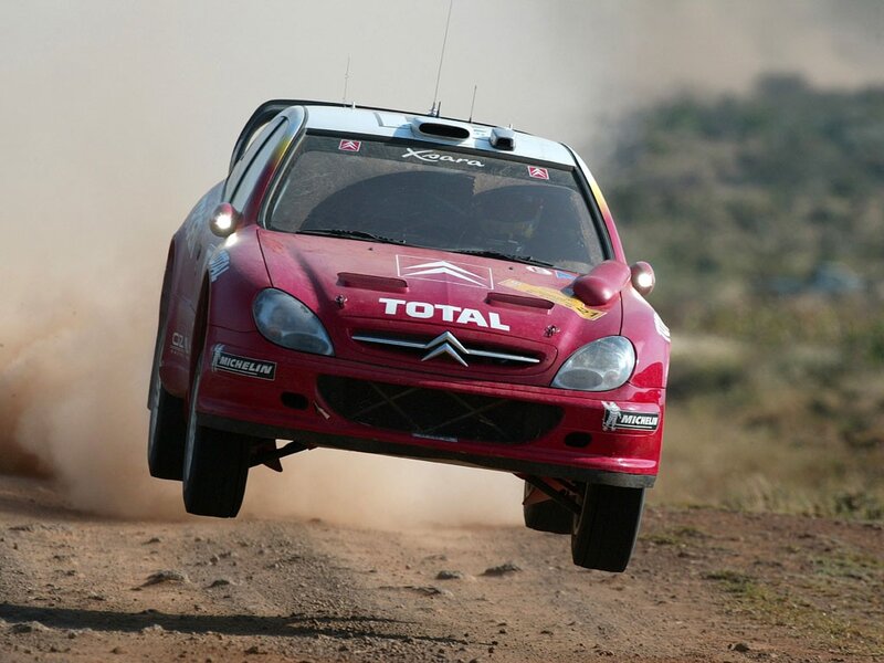 Red rally car in mid-air jump