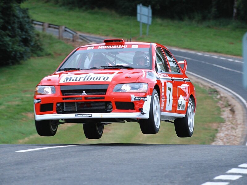 Red rally car in mid-air jump