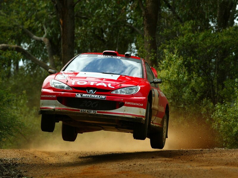 Red rally car in mid-air jump