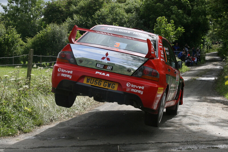 Red rally car in mid-air jump
