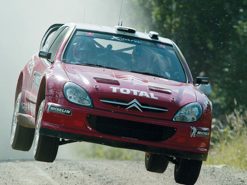 Red rally car in mid-air jump