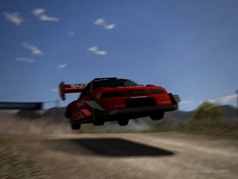 Red rally car in mid-air jump