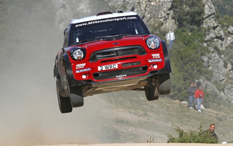 Red rally car in mid-air jump