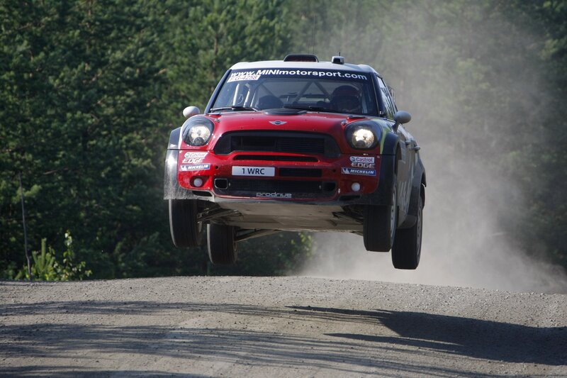 Red rally car in mid-air jump