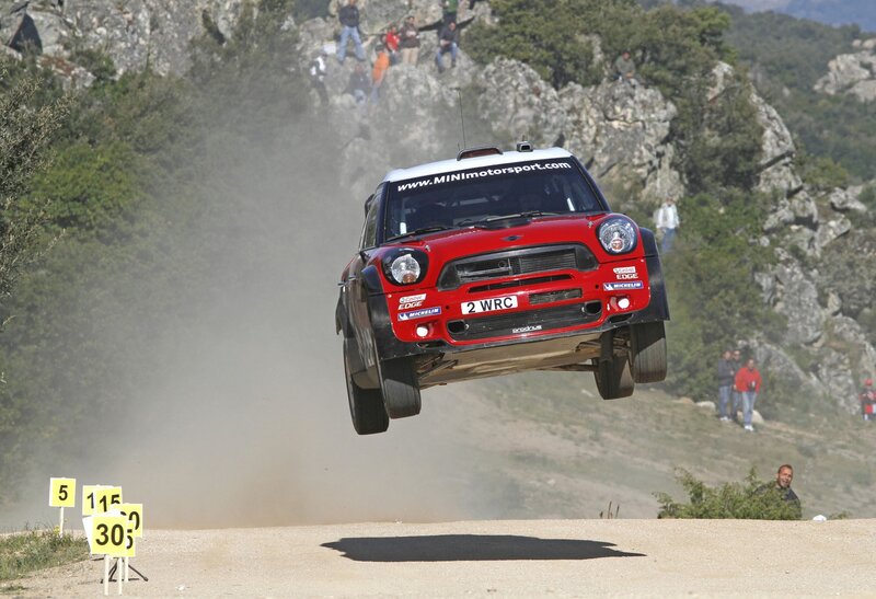Red rally car in mid-air jump
