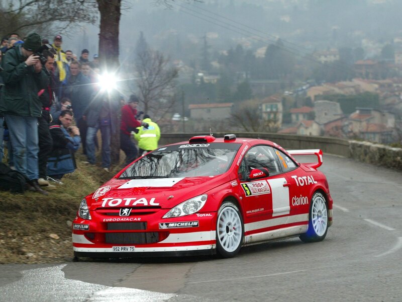 Red rally car on a winding road