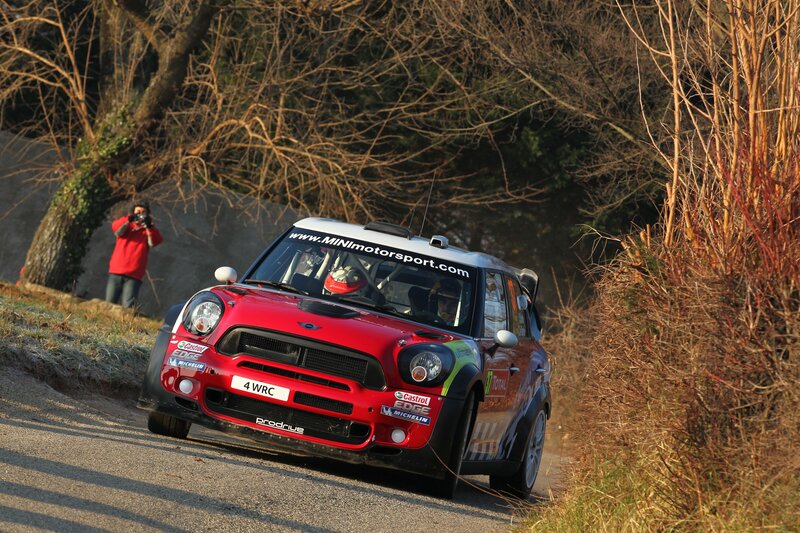 Red rally car on a winding road