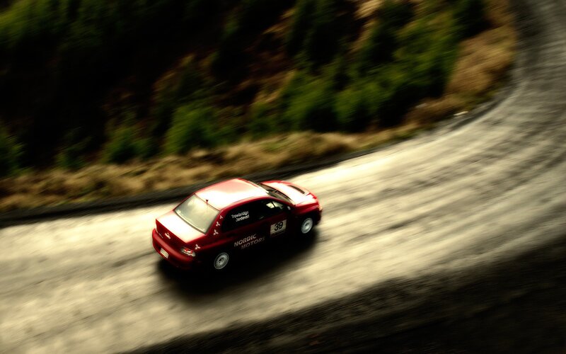 Red rally car on a winding road