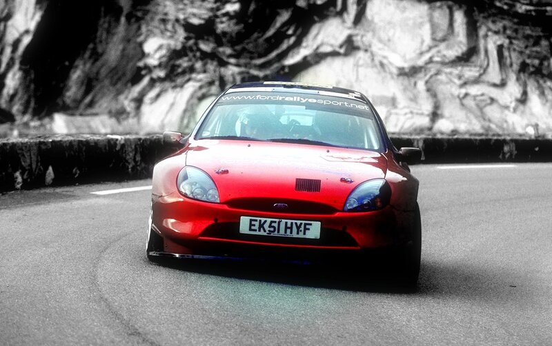 Red rally car on a winding road