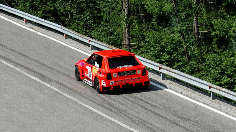 Red rally car on a winding road