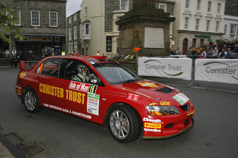 Red rally car on city street