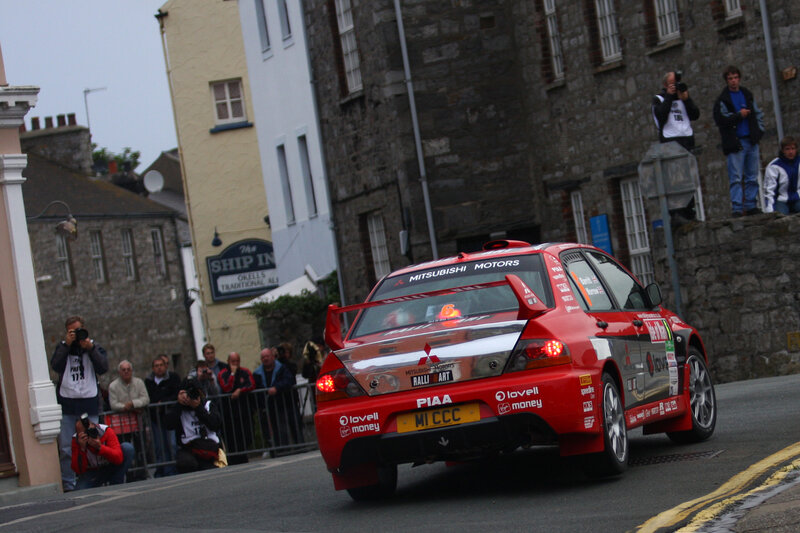 Red rally car on city street
