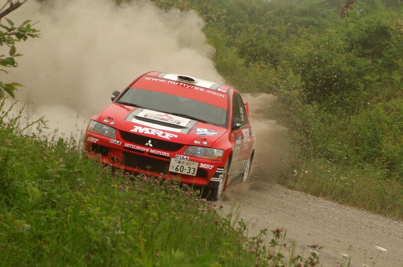 Red rally car on dirt road