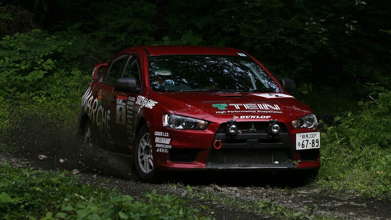 Red rally car on dirt road