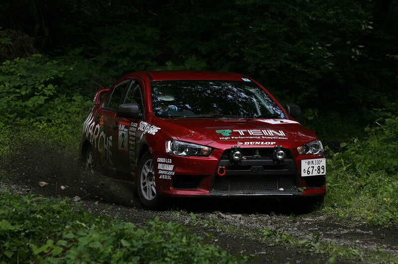 Red rally car on dirt road
