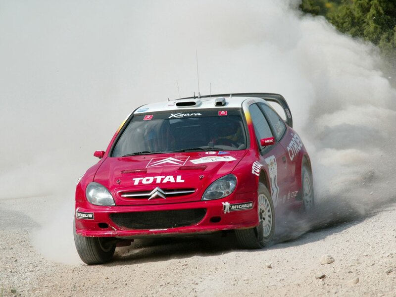 Red rally car on dusty track