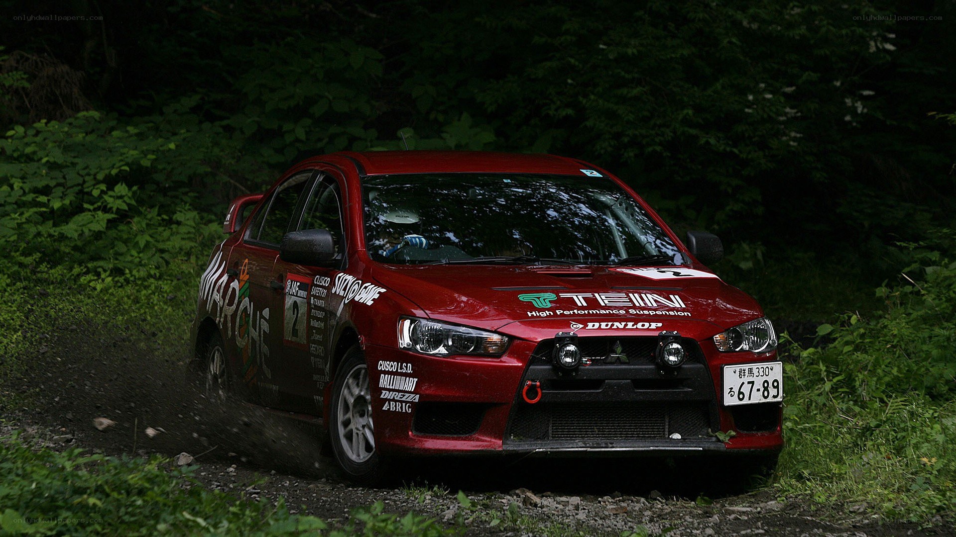 Red rally car on forest track