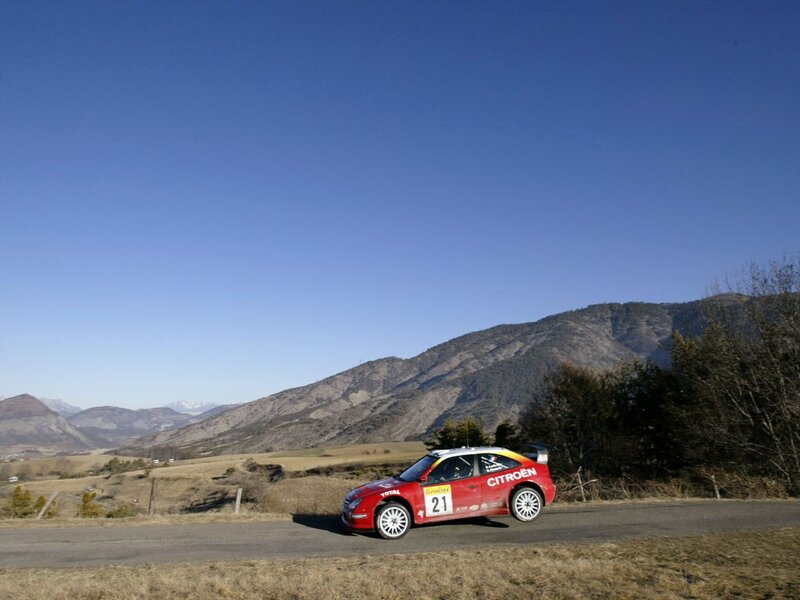Red rally car on mountain road