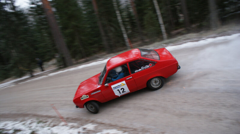 Red rally car on snowy track