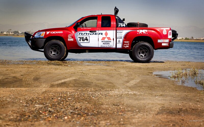 Red rally truck by water