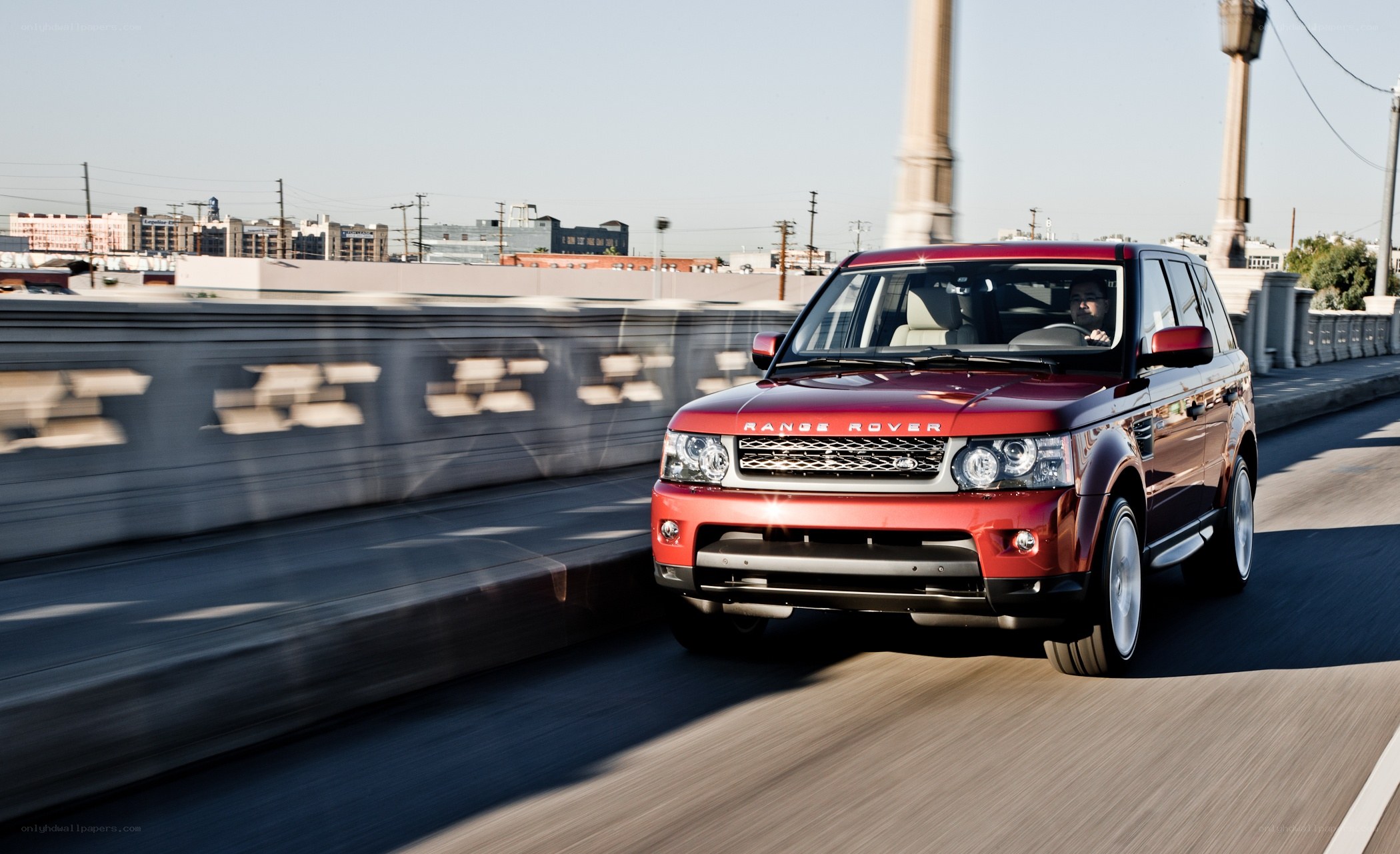 Red Range Rover driving on a bridge