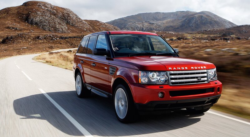 Red Range Rover driving on a road