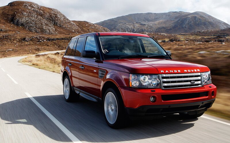 Red Range Rover driving on mountain road