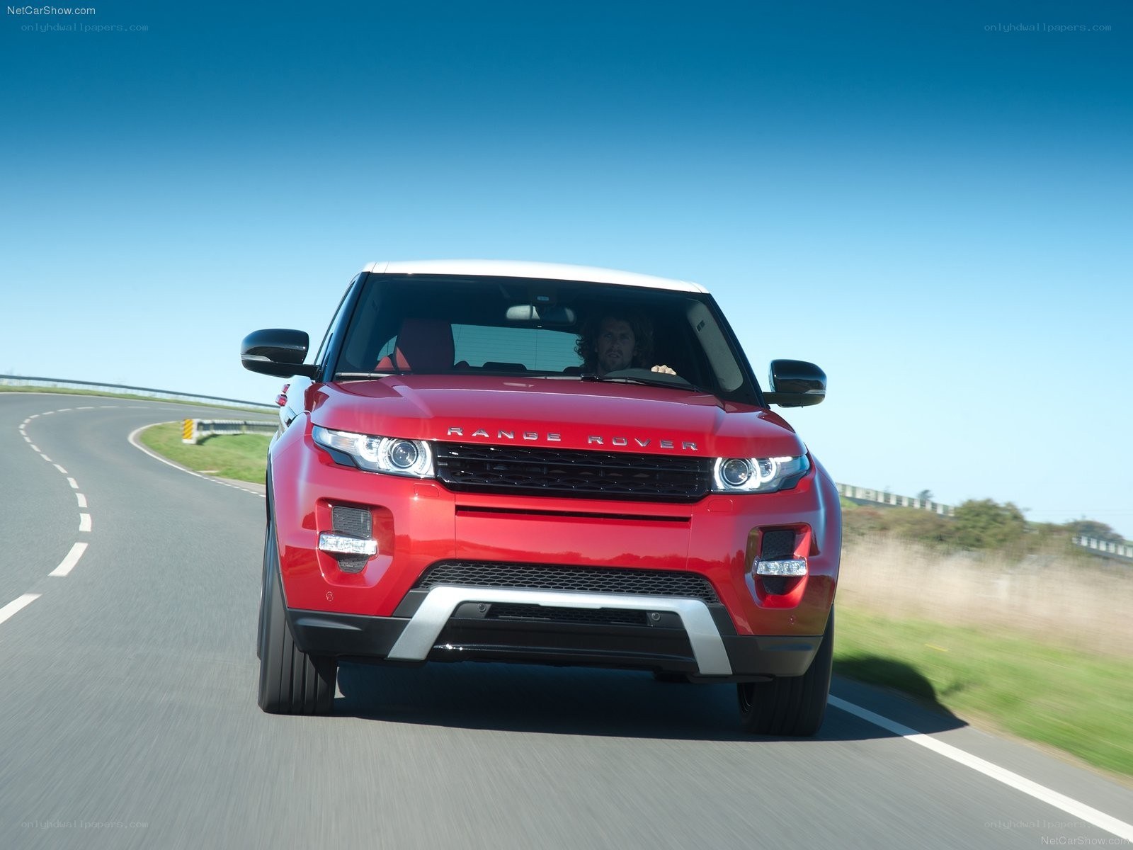 Red Range Rover driving on road