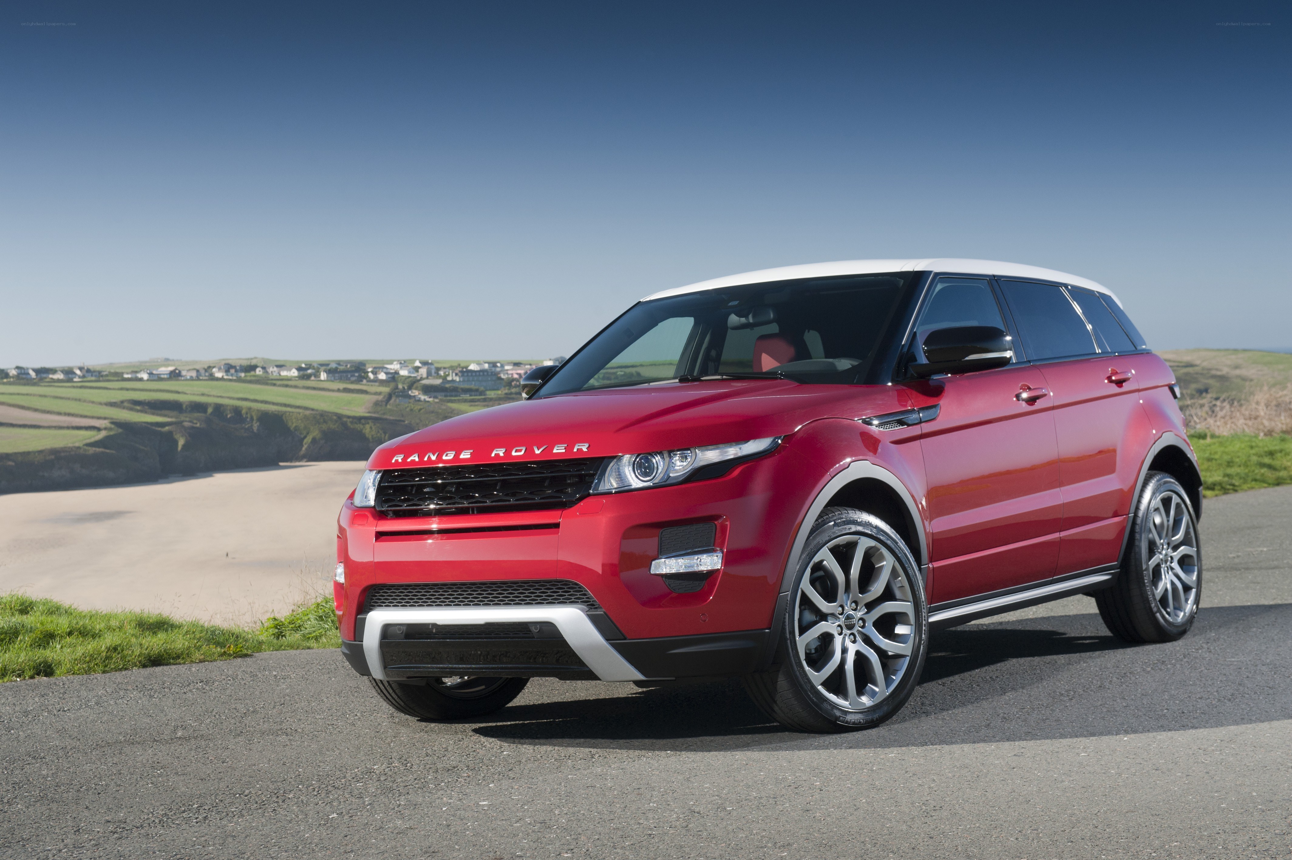 Red Range Rover Evoque on coastal road