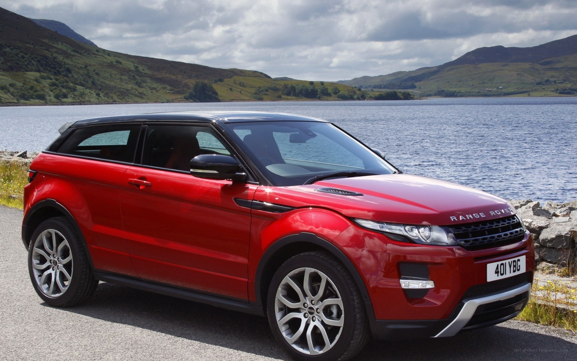 Red Range Rover parked by a lake