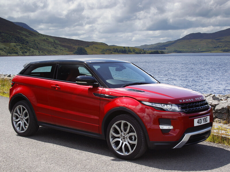 Red Range Rover parked by a lake