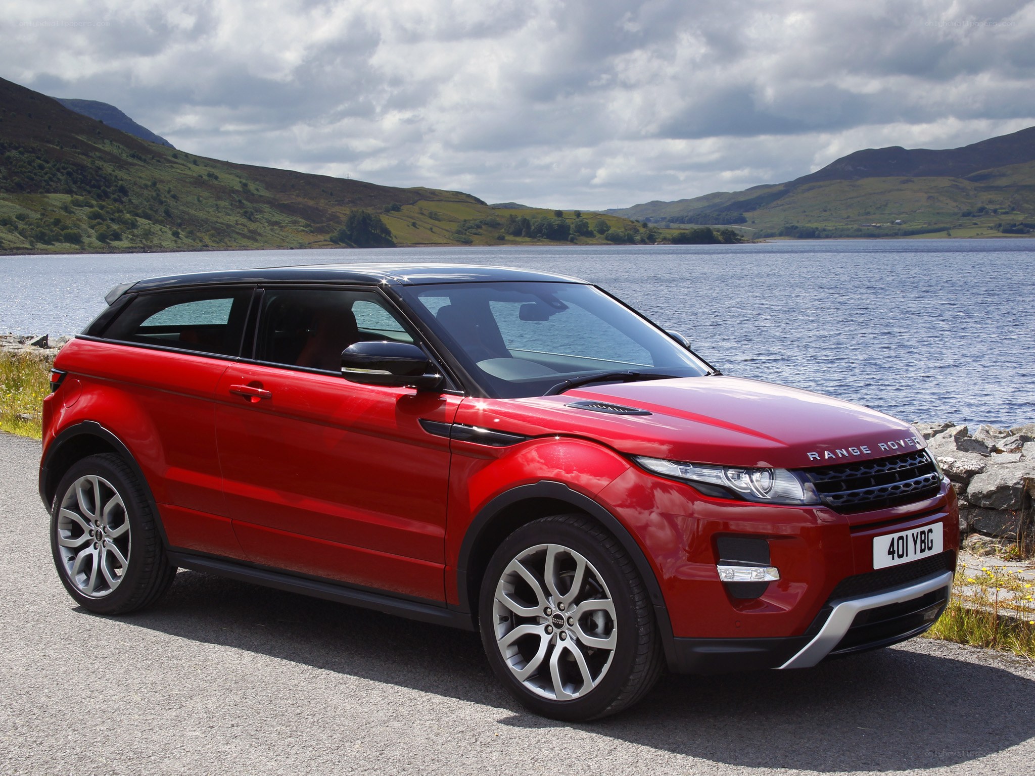 Red Range Rover parked by a lake