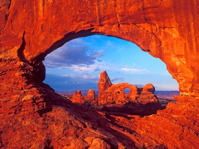 Red rock arch framing distant formations