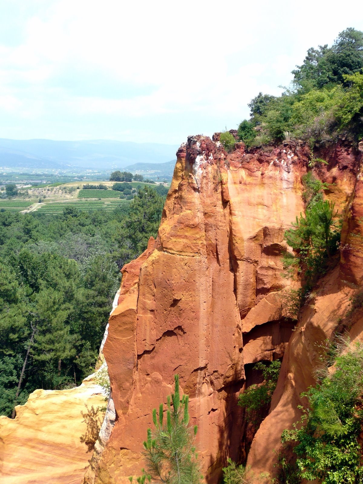 Red rock cliff with green valley