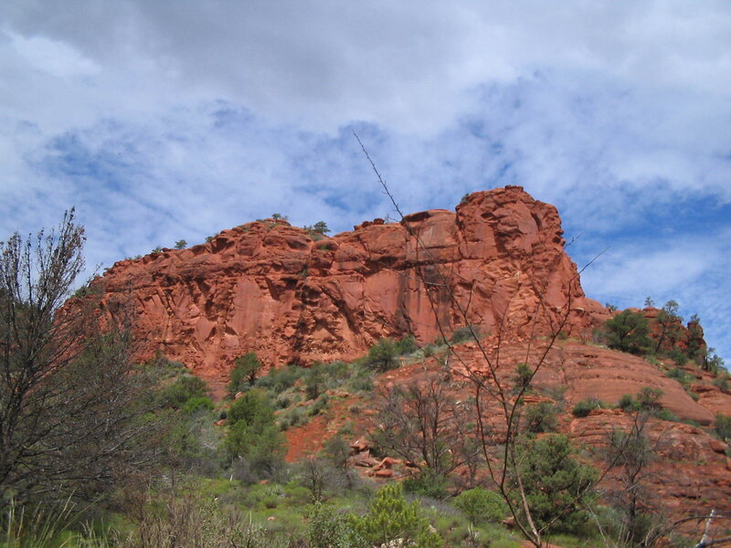 Red rock formation under cloudy sky